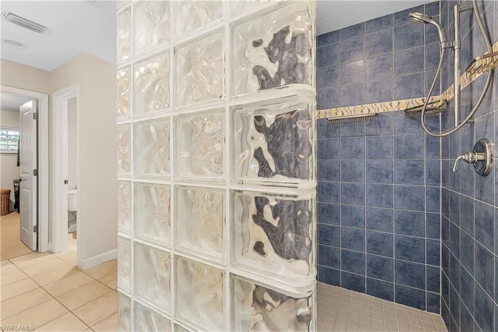 Bathroom featuring tile patterned floors and a tile shower