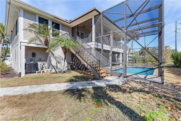 Back of property with a patio and lanai area along with the pool and screened cage