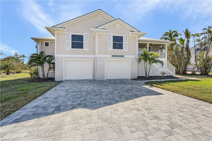 View of front of property featuring a garage and a front yard