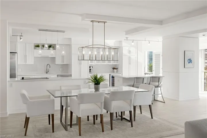 Dining area featuring light wood-style flooring, beverage cooler, and a chandelier