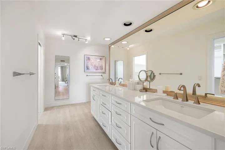 Full bath featuring double vanity and light wood finished floors