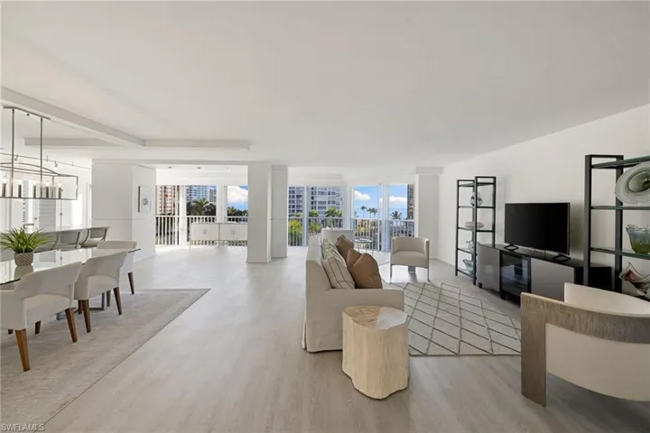 Living room featuring light wood-style floors, plenty of natural light, and suspended lighting