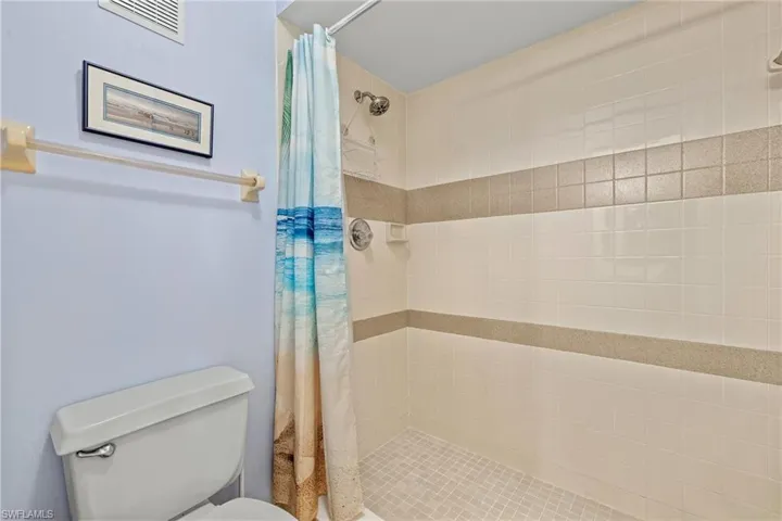 Bathroom with a shower with curtain and toilet