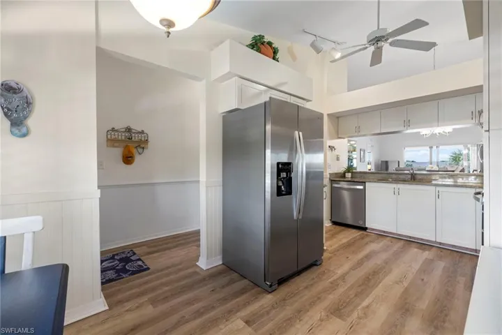Kitchen featuring sink, light hardwood / wood-style flooring, ceiling fan, appliances with stainless steel finishes, and white cabinets