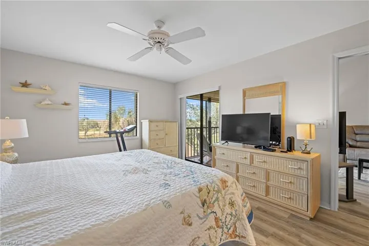 Bedroom with ceiling fan, access to exterior, and hardwood / wood-style floors