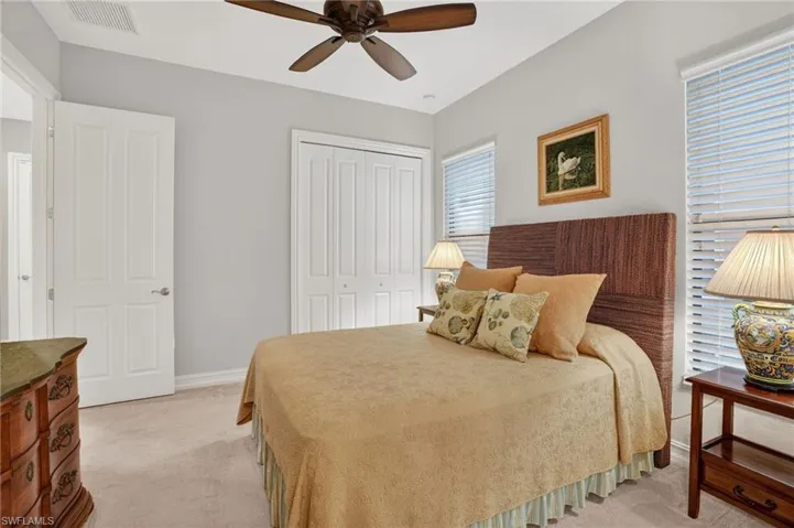 Guest bedroom with light carpet, closet, ceiling fan, and all furniture included
