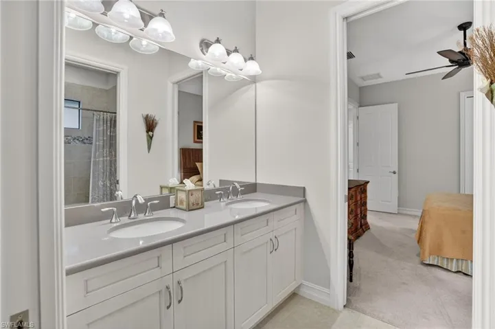 Full guest bath featuring double sinks and sliding pocket doors
