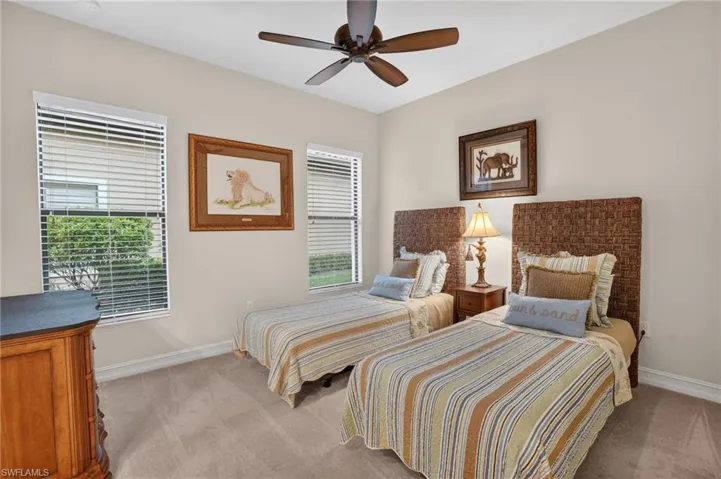 Guest bedroom featuring twin beds, neutral carpet, impact hurricane glass windows, all furniture included.