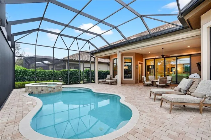 View featuring pool, spa, and extended covered lanai and side view of the panoramic pool screen.  All lanai furniture is included.
