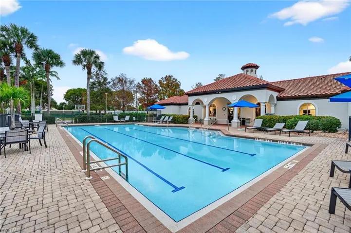 Community pool with deck pavers and poolside furniture