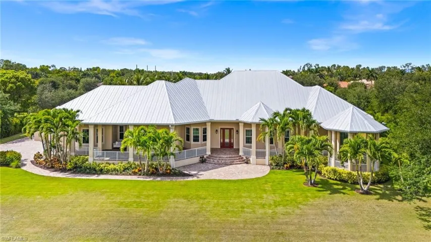 View of front of property featuring a porch, a front yard, and metal roof