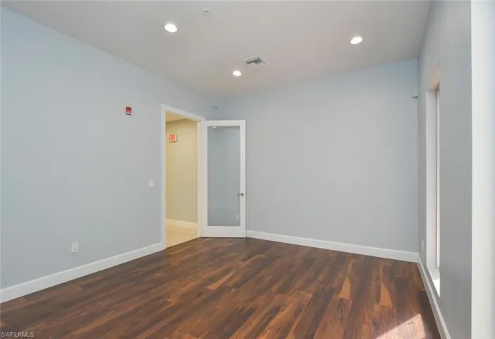 Empty room featuring dark hardwood / wood-style floors