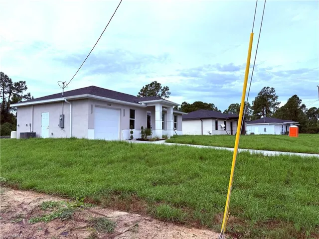 Single story home featuring stucco siding, an attached garage, and a front yard