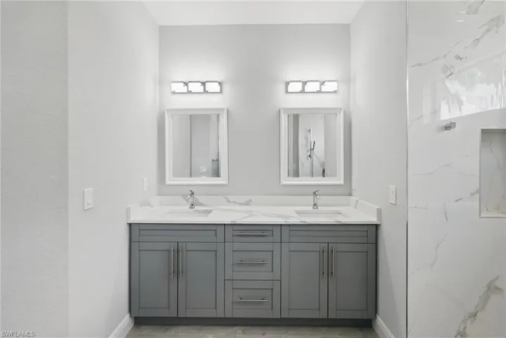 Bathroom featuring double vanity and baseboards