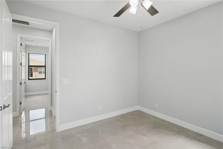 Empty room featuring baseboards and a ceiling fan