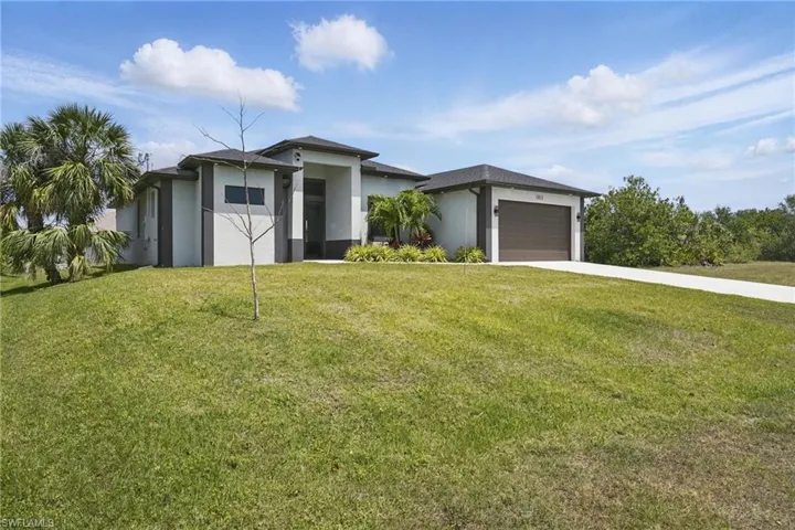 Prairie-style house featuring a front yard, stucco siding, and concrete driveway