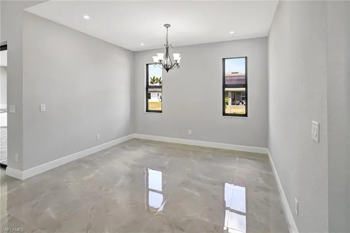 Spare room featuring light marble finish flooring, a chandelier, and recessed lighting