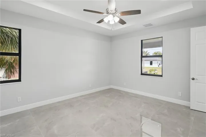 Unfurnished room with a raised ceiling and ceiling fan