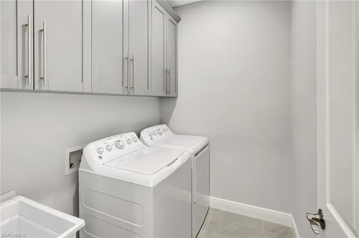 Washroom with washing machine and clothes dryer and cabinet space