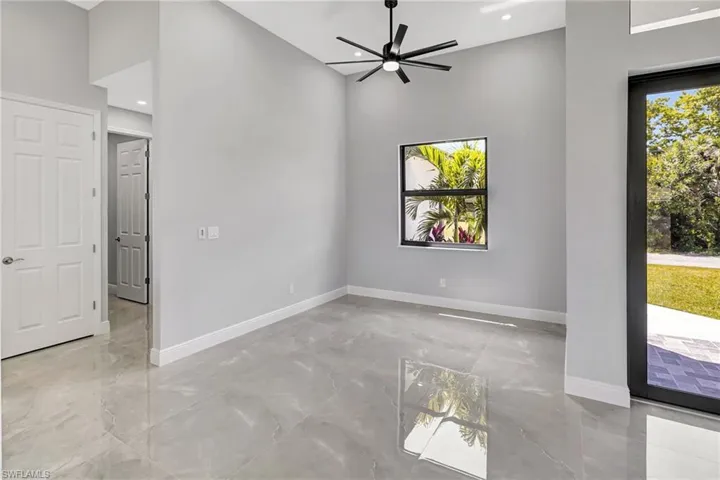 Empty room featuring plenty of natural light, light marble finish flooring, ceiling fan, and recessed lighting