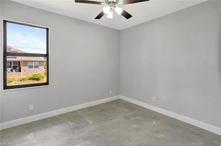 Unfurnished room with baseboards and ceiling fan