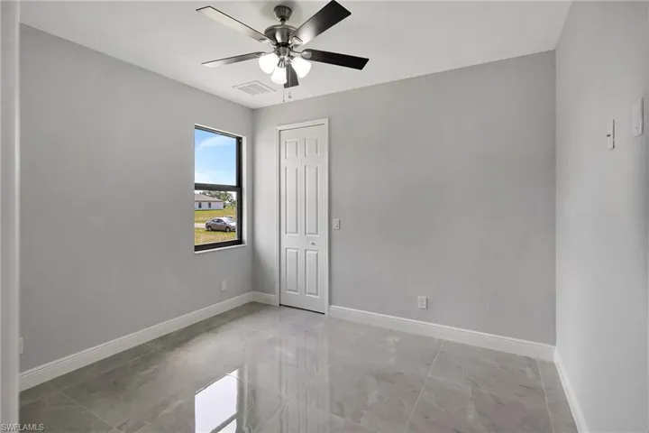 Unfurnished room with light marble finish flooring and ceiling fan