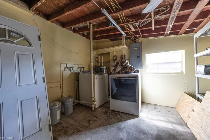 Basement with electric panel and washing machine and clothes dryer