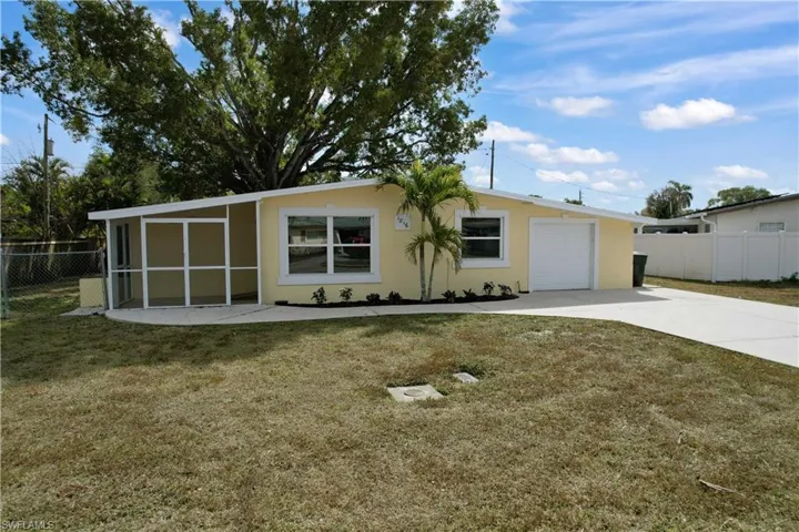 View of front of property featuring stucco siding, driveway, and a sunroom