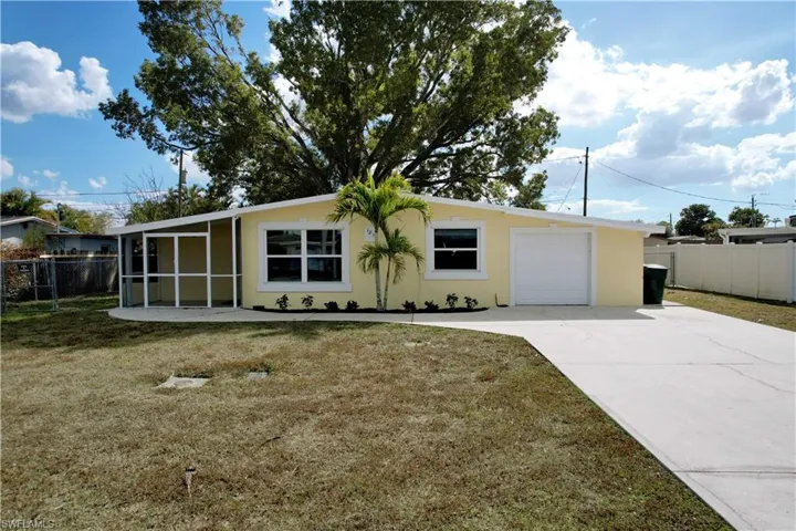 Ranch-style house with stucco siding, concrete driveway, and a sunroom