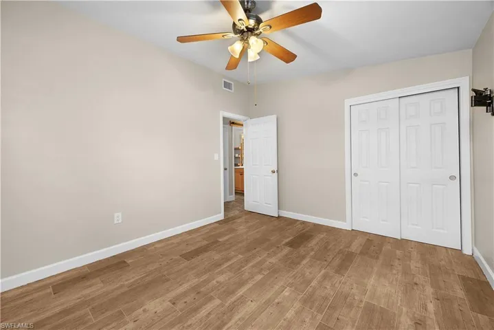 Unfurnished bedroom featuring ceiling fan, light wood-type flooring, and a closet
