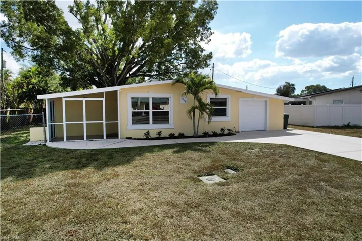 Ranch-style house featuring concrete driveway, stucco siding, a sunroom, and an attached garage