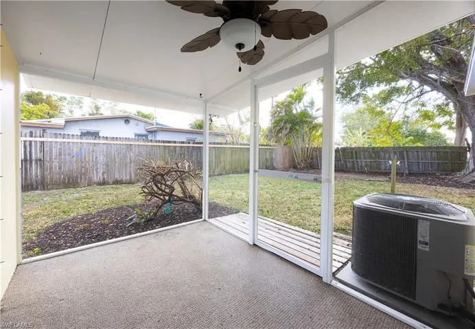 Unfurnished sunroom featuring a ceiling fan and a patio area