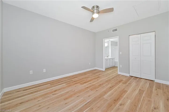 Unfurnished bedroom with a closet, ceiling fan, ensuite bath, light wood-type flooring, and sink