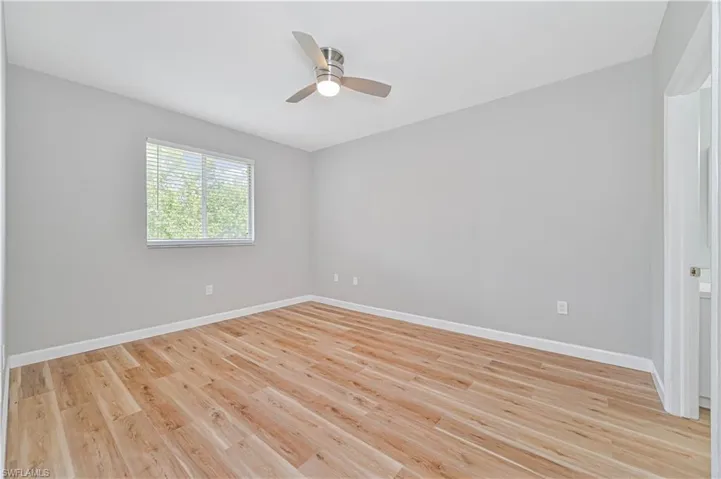 Unfurnished room with ceiling fan and light wood-type flooring