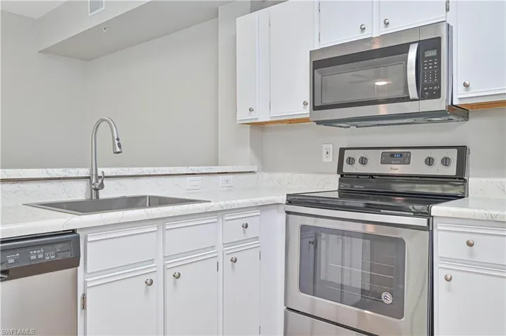 Kitchen with white cabinets, stainless steel appliances, and sink