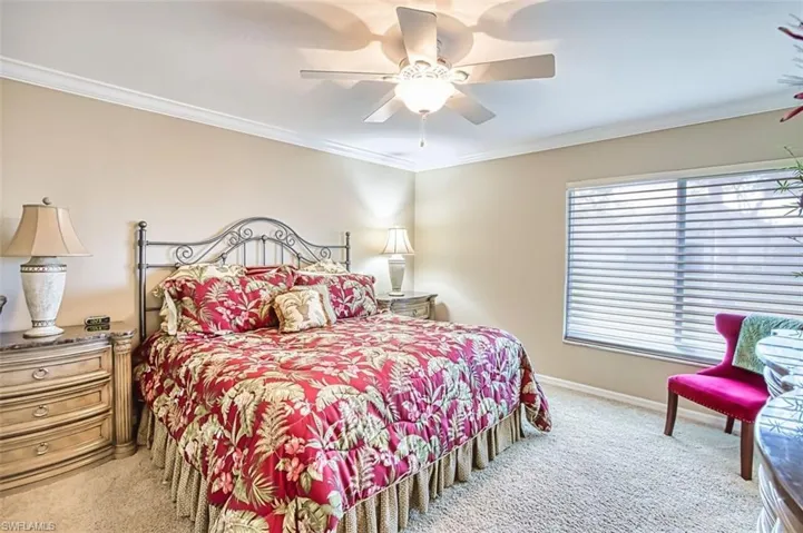 Master Bedroom with ornamental molding, light colored carpet, and ceiling fan
