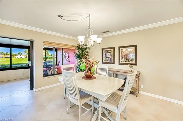 Dining room featuring crown molding, a chandelier, and light tile patterned floors