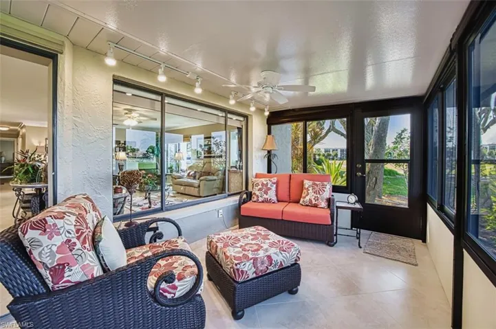 Sunroom featuring ceiling fan, an outdoor hangout area, and rail lighting