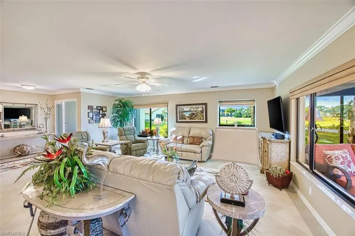 Living room with a ceiling fan and ornamental molding