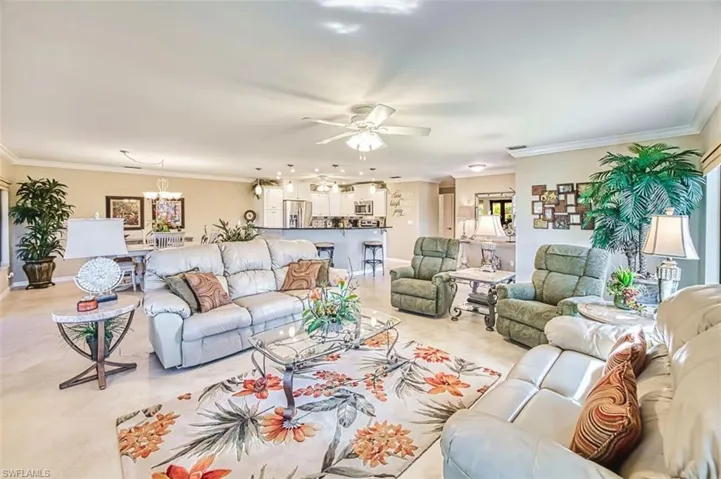 Living room with crown molding and ceiling fan