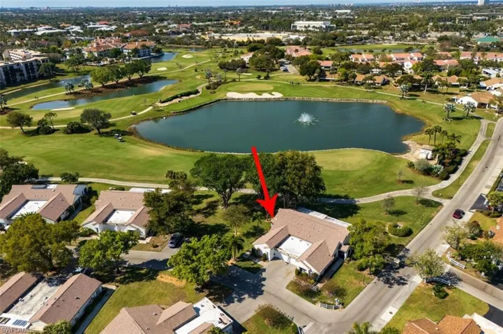 Aerial view of property's location featuring a golf club and nearby suburban area