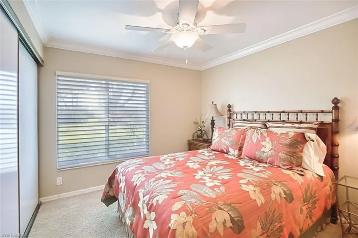 Guest Bedroom featuring ornamental molding, light colored carpet, a ceiling fan, and a closet