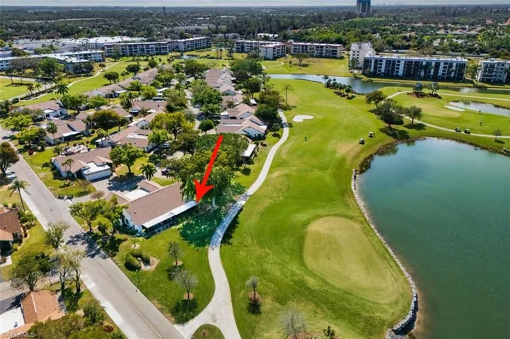 Aerial view of property's location featuring a golf club and a nearby body of water