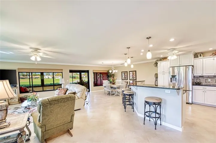 Living room featuring ceiling fan, ornamental molding, light tile patterned floors, and recessed lighting
