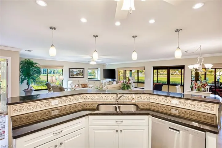 Kitchen with ceiling fan, white cabinets, dark stone counters, dishwasher, and open floor plan