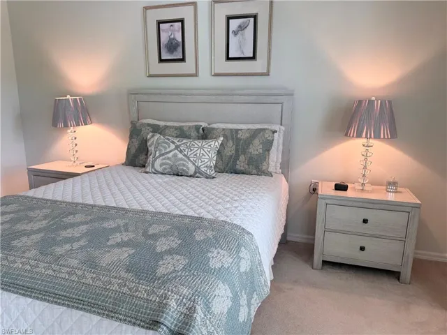 Bedroom featuring light carpet and baseboards