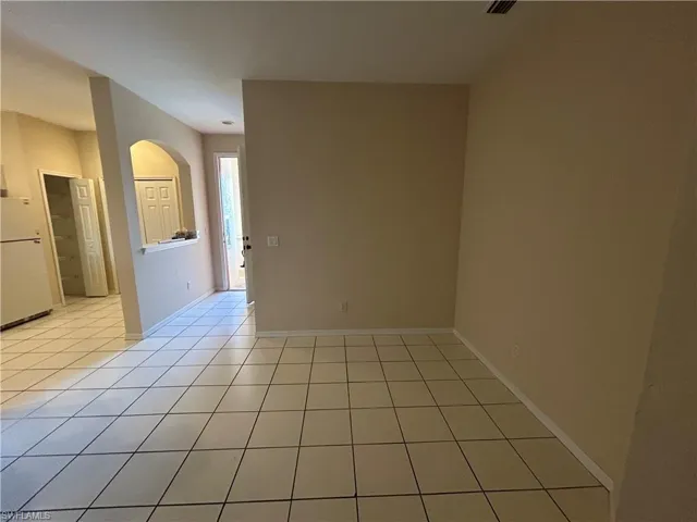 Unfurnished room featuring light tile patterned floors and baseboards