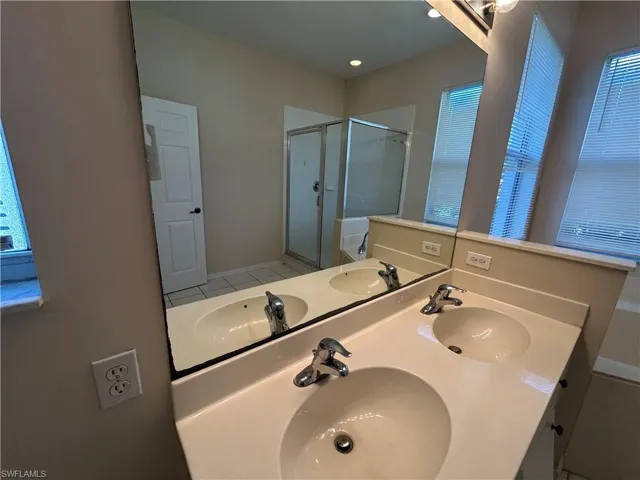 Bathroom with double vanity and a stall shower