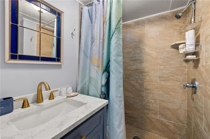 Bathroom featuring a shower with curtain and vanity
