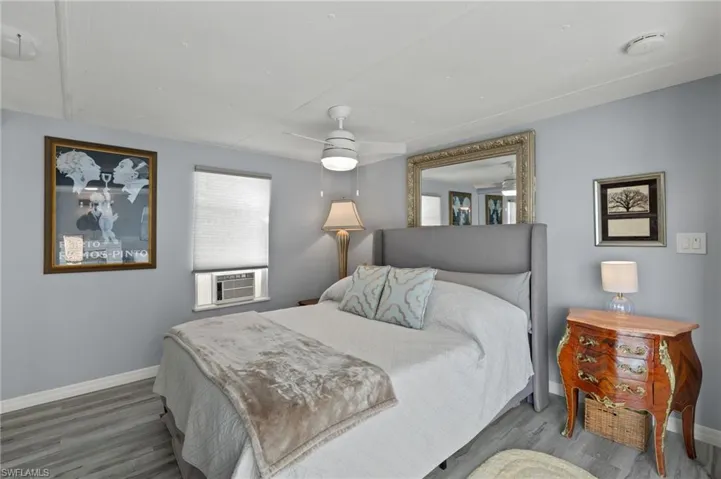 Bedroom featuring wood-type flooring, ceiling fan, and cooling unit